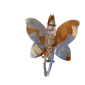 French butterfly acetate hair claw with amber marble pattern and gold logo detail