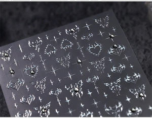 Macro detail of Y2K chrome nail stickers with metallic hearts and stars on black plush