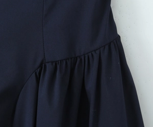 Détail de la texture froncée bleu marine et des coutures plissées de la robe bustier
