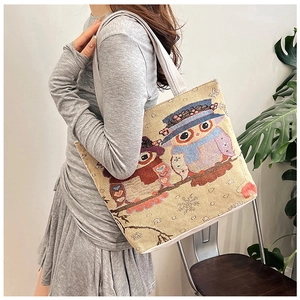 Detailed texture of canvas tote featuring owl embroidery and ethnic woven patterns