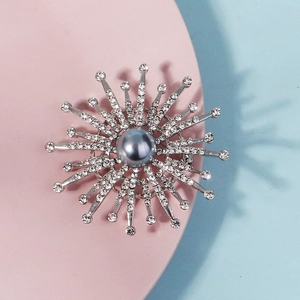 Close-up of silver sunflower brooch with grey pearl and sparkling rhinestones