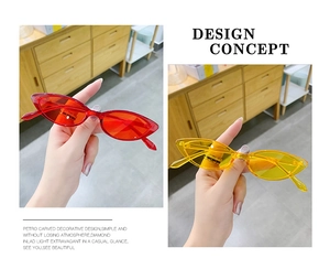 Close-up of red and yellow transparent cat-eye sunglasses featuring a retro hip-hop design