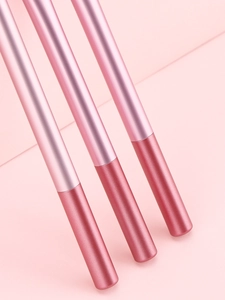 Gros plan de trois pinceaux à maquillage roses avec manches métalliques roses