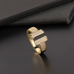 Detailed macro view of gold-finished double-T ring with sparkling zircon pavé setting