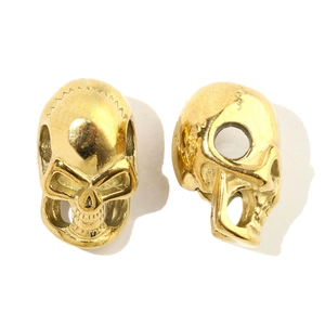 Detailed view of skull-shaped golden metal beads for DIY jewelry and bracelet making