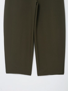 Detail view of stitched cuff and olive green woven fabric texture on balloon trousers