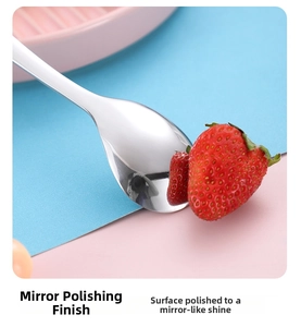 Detail of mirror-polished stainless steel baby spoon reflecting fresh strawberries