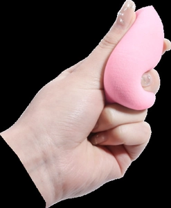 Close-up of pink makeup sponge being squeezed to show soft elastic sponge texture