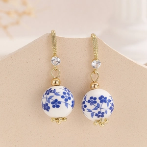 Elegant porcelain drop earrings with blue floral beads and long tassels in gold