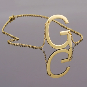 Macro d'un collier en acier inoxydable doré 18K avec pendentif lettre G et chaîne O