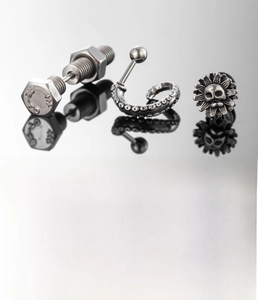 Macro shot of silver titanium steel earrings with screw head details and A2-70 stamp