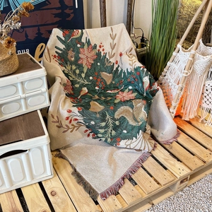 Detailed view of woven jacquard throw with squirrel motifs and soft fringe edges