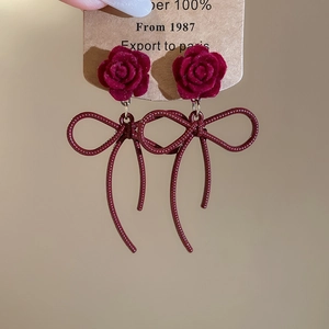 Detail of red velvet rose and burgundy metallic bow pendant on these vintage earrings