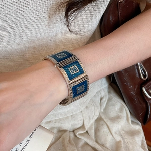 Detailed shot of vintage blue enamel square bracelet with gold spiral patterns