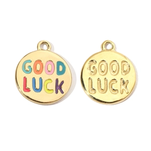 Detailed macro of golden stainless steel pendants with Good Luck engraving and enamel inlay