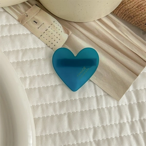 Detail of a dark blue heart-shaped acetate hair clip with gold France Handmade text