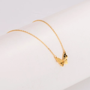 Exquis collier avec pendentif papillon doré, élégamment présenté sur un socle blanc