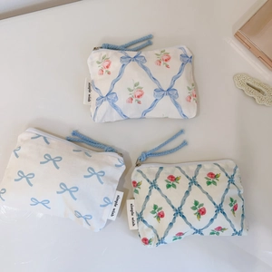 Close-up of floral cotton pouches featuring ribbon patterns and woven zipper pulls