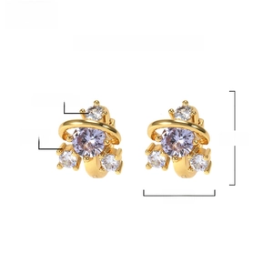 Detailed macro of gold plated brass earrings featuring round purple and white zircons