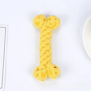 Macro detail of a bright yellow braided cotton rope dog toy in a bone shape for chewers