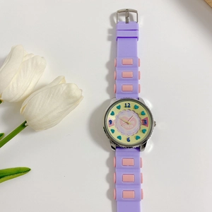 Detail of purple silicone kids watch with pink accents and yellow heart patterned dial