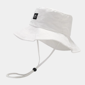 White wide brim bucket hat with black smiley patch and adjustable windproof cord