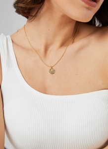 Close-up of a gold-plated rose relief pendant necklace on a female model neck