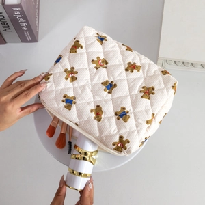 Detailed view of quilted bear print makeup bag with brushes and lipstick storage