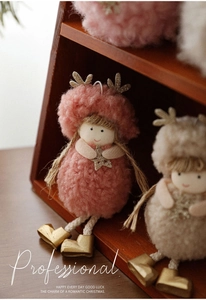 Macro detail of plush Christmas angel dolls with golden antlers and fuzzy clothes