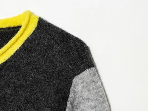 Close-up of contrast knit sweater featuring yellow ribbed collar and fuzzy mohair texture