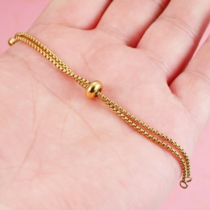Adjustable golden stainless steel box chain bracelet with sliding clasp in hand