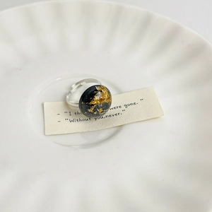 Detail view of heart-shaped resin ring with gold foil inlay on a ceramic dish