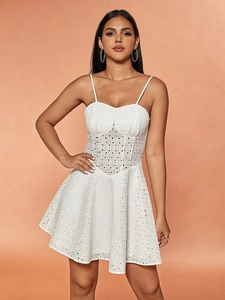 White lace mini dress with spaghetti straps and corset-style bodice on warm background