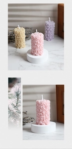 Dettaglio macro di tre candele a colonna a forma di rosa con intagli floreali testurizzati