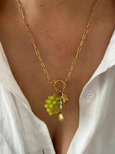 Detailed close-up of 18K gold paperclip chain with grape bead and shell pendants