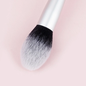 Detail of soft bicolored flame-shaped makeup brush bristles and silver matte ferrule