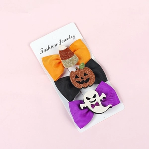 Detailed view of Halloween bow hair clips with glitter pumpkin and ghost patterns