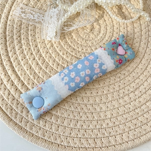 Detail of floral fabric cable organizer with white lace, blue and pink heart buttons