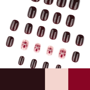Deep wine red false nail set with floral accents and silver beads on oval tips