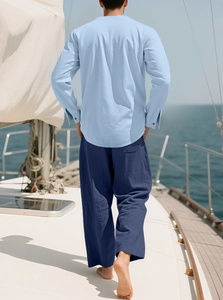 Detail von hellblauem Leinenhemd und marineblauer Hose auf einer Jacht am Meer