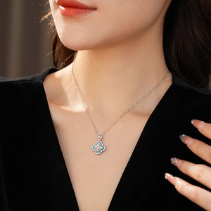 Macro detail of silver flower pendant necklace with blue stones on a model