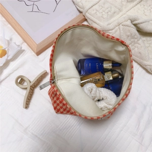 Detailed interior of orange houndstooth cotton bag showing skincare storage capacity