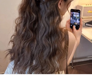 Detail of elegant wavy brown hair styled with a minimalist hair claw in a cozy setting
