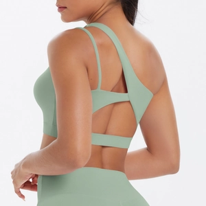 Detail of sage green sports bra with asymmetric straps and geometric back cutout