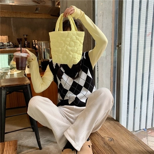 Detailed texture of quilted floral pattern on light yellow padded tote diaper bag