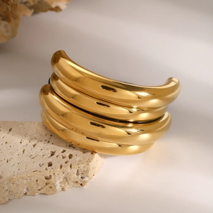Close-up of polished gold-plated stainless steel ponytail holder on a stone base