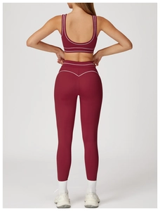 Detail of high-waisted yoga pants and sports bra set with white contrast piping details