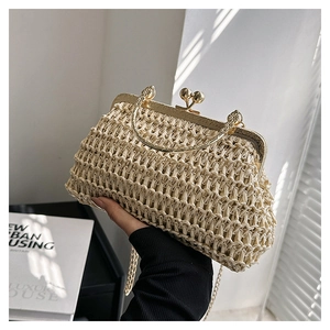 Dettaglio borsa a conchiglia intrecciata beige con manico in metallo dorato e chiusura