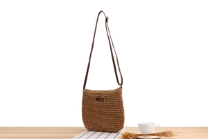 Detailed texture of brown woven paper rope crossbody bag with premium leather strap