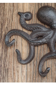 Makro-Seitenansicht der Wandhaken aus Gusseisen im Oktopus-Design auf rustikalem Holz